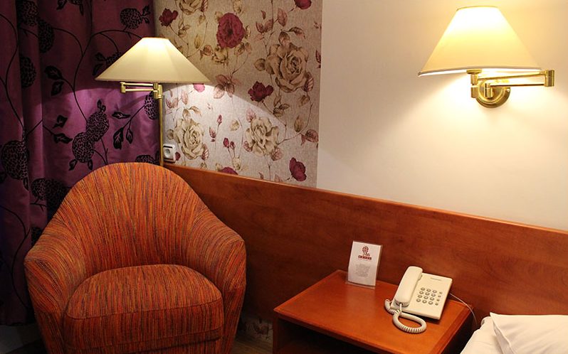 Armchair, wall lamp and telephone in the single room