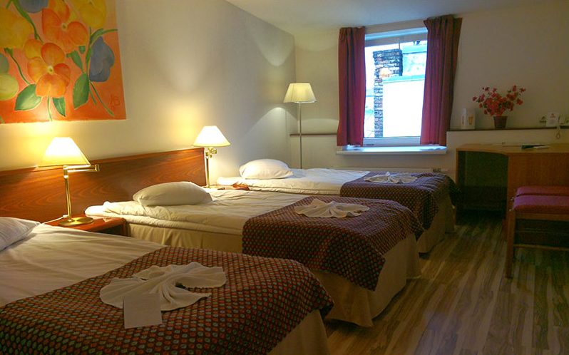 Triple room with three beds and bedspreads